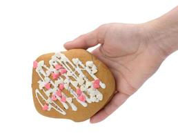 hand- houdt gebakken Kerstmis peperkoek geïsoleerd Aan wit achtergrond foto