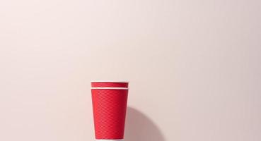 papier karton rood cups voor koffie, beige achtergrond. milieuvriendelijk servies, nul verspilling foto