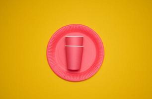 rood papier cups en borden Aan een geel achtergrond. recyclebaar afval, afwijzing van plastic, top visie foto