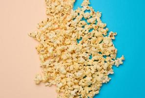 hoop van gebakken popcorn met kaas Aan een blauw achtergrond foto