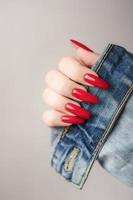 hand- van een jong meisje met rood manicure Aan nagels foto