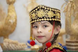 Wit-Rusland, stad van gomel, mei 21, 2021 kinderen vakantie in de stad. een weinig meisje in de Oezbeeks nationaal hoofdtooi. foto