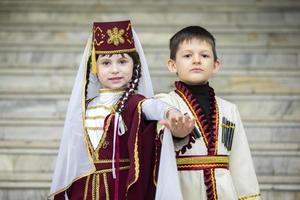 Wit-Rusland, stad van gomel, mei 21, 2021 kinderen vakantie in de stad. een jongen en een meisje in nationaal Georgisch kleren. foto