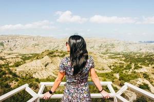 brunette vrouw staat Aan de platform gezichtspunt en looks links over- mooi landschap van vashlovani natuur reserveren foto