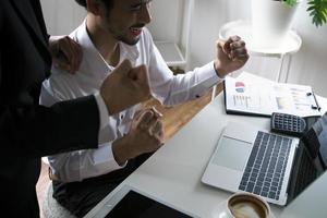 de manager en de personeel keek blij terwijl aan het kijken de computer Bij de vergadering tafel. winnaar concept foto