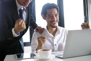 de manager en de personeel keek blij terwijl aan het kijken de computer Bij de vergadering tafel. winnaar concept foto