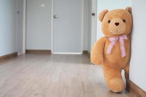 achtergrond voor kinderen Speel teddy beer, bruin haar- staand achter de muur. verbergen de geheim van kinderen foto