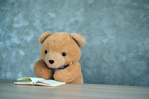 teddy beer Holding een potlood lezing een boek. tentamen voorbereiding voor kinderen. de voornemen van de kind. foto