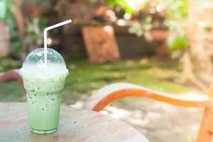 ijs groen thee in plastic kop Aan tafel in de tuin foto