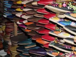 kleurrijk handgemaakt leer slippers aan het wachten voor klanten Bij winkel in fes, De volgende naar leerlooierijen, Marokko foto