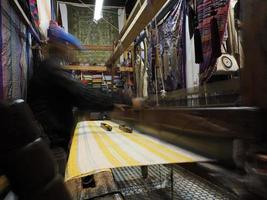 dichtbij omhoog van de draden in een houten weefgetouw in een textiel op te slaan in fes, Marokko foto