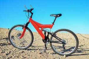 rood fiets in de woestijn foto
