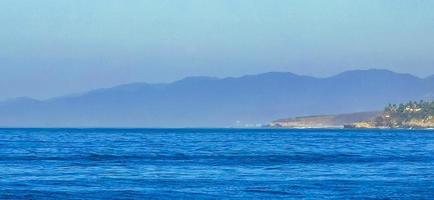 strand zand blauw water reusachtig surfer golven puerto escondido Mexico. foto