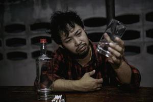 Aziatisch Mens drinken wodka alleen Bij huis Aan nacht tijd, thailand mensen, spanning Mens dronken concept foto