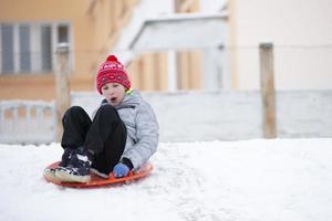 kind in winter. de jongen is rodelen. foto