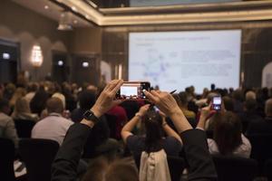 Wit-Rusland, stad van Minsk, september 26, 2019. openbaar evenement. toeschouwers Bij de conferentie. de kijker handen met een smartphone nemen afbeeldingen van de presentatie. foto