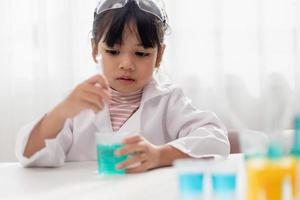 opleiding, wetenschap, chemie en kinderen concept - kinderen of studenten met test buis maken experiment Bij school- laboratorium foto