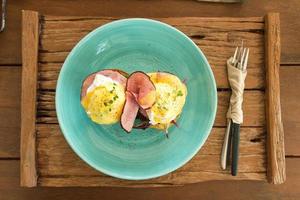 Eggs Benedict op blauw bord foto