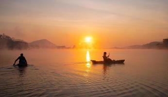 Dames Aan kajak rijen in de reservoir gedurende de zonsopkomst, harak Woud park huai naam Mens reservoir loei Thailand 21 jan 2023 foto