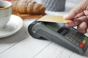 contactloos betalingsconcept met jonge man die met creditcard betaalt foto