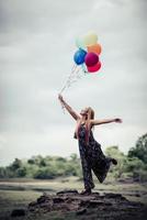 jonge vrouw met kleurrijke ballonnen in de natuur foto