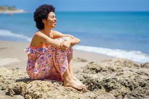 gelukkig Afrikaanse Amerikaans vrouw uitgeven tijd Aan strand foto