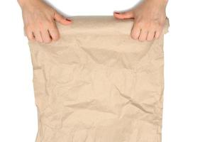 vrouw handen Holding een gerold rollen van bruin verfrommeld papier geïsoleerd Aan wit achtergrond foto