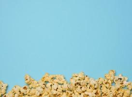 hoop van gebakken popcorn met kaas Aan een blauw achtergrond foto