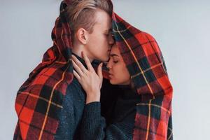 met rood handdoek. schattig jong paar omarmen elk andere binnenshuis in de studio foto