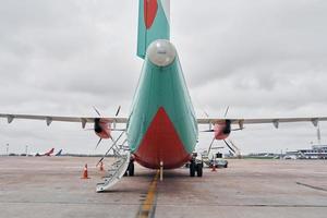 oranje en blauw gekleurd. turboprop vliegtuig geparkeerd Aan de landingsbaan Bij dag foto