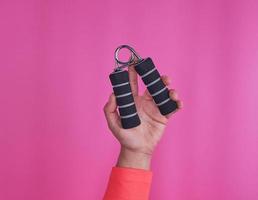 zwart spander in vrouw hand- Aan roze achtergrond foto