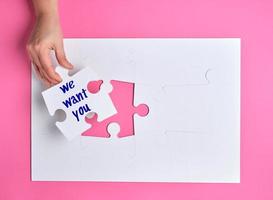 hand- Holding een wit puzzel met de woorden wij willen u foto