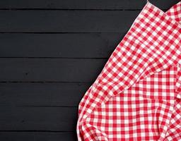 wit rood geruit keuken handdoek Aan een donker blauw houten achtergrond foto