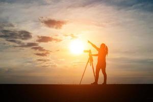 silhouet van een fotograaf fotograferen bij zonsondergang foto