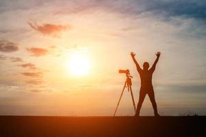 silhouet van een fotograaf fotograferen bij zonsondergang foto