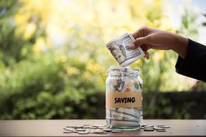 geld in een glazen pot in de natuur, investeringsconcept foto