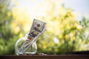 geld in een glazen pot in de natuur, investeringsconcept foto