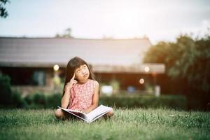 meisje dat een boek in haar huistuin buiten leest foto