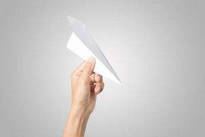vrouw hand met een papieren vliegtuigje geïsoleerd op een witte achtergrond foto