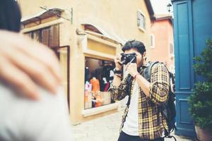 jonge man die foto's van zijn vrienden maakt terwijl hij samen in stedelijk gebied reist