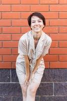 vrolijk vrouw in huis slijtage pyjama- buitenshuis steen muur achtergrond emoties - nachtkleding en huiskleding concept foto