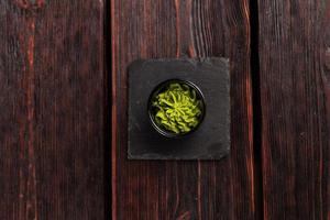 groen wasabi saus of Plakken in kom Aan houten achtergrond top visie foto