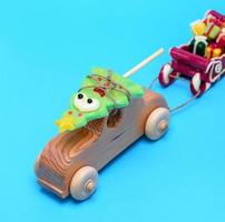 houten kinderen auto draagt een karamel vakantie net en trekt een slee met cadeaus foto