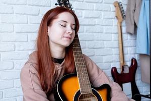 jonge vrouw gitaarspelen thuis foto