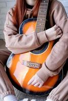 jonge vrouw gitaarspelen thuis foto