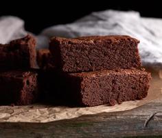 stack van gebakken plein stukken van chocola brownie taart Aan bruin perkament papier foto