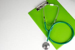 medisch stethoscoop en groen papier houder foto