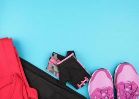 roze vrouwen sportschoenen en kleren voor sport- Aan een blauw achtergrond foto