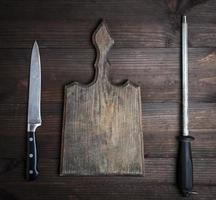 oud bruin houten snijdend bord en mes met verscherping foto