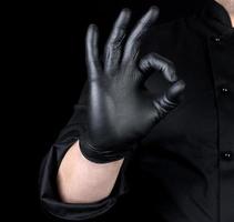 mannetje chef-kok hand- in zwart latex handschoenen en zwart uniform shows gebaar foto